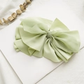 Close-up of light green fabric bow hair clip with ribbons on elegant white background - Fruit Green Pleated
