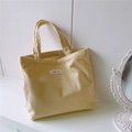 Detail view of beige corduroy tote bag showing the texture and simple wish logo - Light Yellow