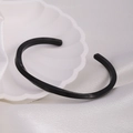 Macro view of black Mobius cuff bracelet featuring engraved Roman numerals on a silk backdrop - 55*70mm / Black