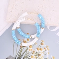 Dettaglio di perle heishi blu e bianche su orecchini a cerchio dorati bohémien - Blu Macchiato
