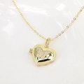 Detailed view of an openable gold heart locket necklace with a diamond butterfly pattern - Butterfly