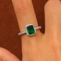 Macro shot of emerald-cut green gemstone ring with halo diamonds on a silver band - Silver Emerald Cut Green Ring (M-132)