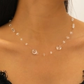 Close-up of clear crystal drop necklace with faceted beads on black lace top - White K S453
