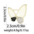 Vista detallada de un broche de mariposa con esmalte blanco y pedrería brillante - Broche de Mariposa
