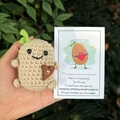 Nahaufnahme einer handgehäkelten Kartoffel-Puppe mit Herzknopf und Motivationskarte - Sprossen Kartoffel Mit Tasche