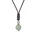 Gros plan de deux perles en pierre verte sur un cordon tressé avec texture - Collier Aventurine