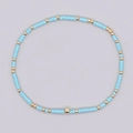 Pulsera artesanal con cuentas cilíndricas azul cielo y esferas metálicas doradas - Cuentas Azul Cielo Oro