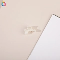 Detailed view of a small mermaid tail hair clip with four faux pearls on a clean surface - Fish Tail