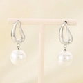 Macro view of silver irregular hollow earrings with large white pearls on a display - Steel Waterdrop (KE115798-GC)