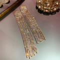 Macro detail of silver drop earrings with long rhinestone tassels in a luxury setting - Gold with Full Zirconia