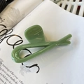 Close-up of a pale green claw clip with smooth resin finish on an open magazine page - Butterfly Buckle Ribbon (Approx 12cm) / Leaf Green
