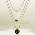Drielaagse gouden ketting met hart- en sterbedels en een zon-maan emaille hanger - Zwart