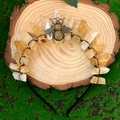 Detailed shot of yellow crystal crown with brass bee on a rustic wooden slice - Citrine + Bronze Wire + Bee