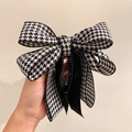 Dettaglio di un fermaglio per capelli con fiocco in tessuto pied de poule bianco e nero - Pied de Poule Nero