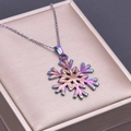 Detailed macro view of an aurora-colored snowflake pendant on a gold jewelry box - Necklace Set / Iridescent Pendant Necklace