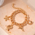 Close-up of a gold-plated bracelet featuring starfish, shell, and dolphin charms - Gold Dolphin Conch Starfish Chain Bracelet