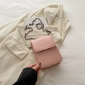 Chic pink crossbody phone bag with sleek chain strap on elegant blazer background - Pink