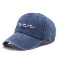 Close-up of white wave embroidery on a washed blue cotton baseball cap with fine stitching - Navy Blue