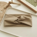 Macro shot of khaki knitted knotted headband on a rustic tray showing soft texture - Khaki