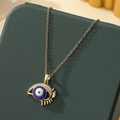 Collier oeil bleu turc avec cils dorés présenté sur un coffret à bijoux vert foncé - A23-or