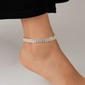 Detalle macro de la tobillera de plata con pedrería brillante en el tobillo de mujer - Estilo A Tobillera De Plata / Plateado