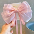 Detail of pink large double-layered organza bow hair clip with long ribbons and satin texture - Princess Pink