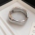 Detailopname van een zilveren golvende metalen armband met gepolijste vloeibare look - Onregelmatige Stijl / Zilver