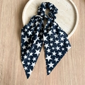 Detailed view of USA flag pattern scrunchie with stars and long ribbon on a tray - Star Blue Ribbon