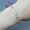 Dettaglio del bracciale aperto dorato con tre zirconi ovali e pavé di cristalli - Stile di Chiusura a Tripla Pietra Ovale (B)