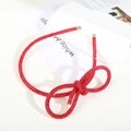 Detailed view of red rhinestone bow headband with shiny crystals and gold end tips - Figure 8 Knot Full Rhinestone Headband / Red Zircon