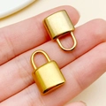 Deux breloques cadenas en forme de cœur en acier inoxydable doré tenues en main - Grande serrure à surface incurvée