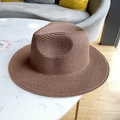Detailed cross-weave texture of a brown straw fedora hat for summer sun protection - Coffee