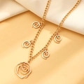 Detailed view of a gold spiral flower pendant necklace on soft pleated fabric background - KC Gold Necklace (X113)