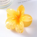Detailed macro view of high-gloss yellow resin plumeria flower hair claw clip - Yellow 7cm