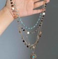 Macro detail of multi-layered gold necklace with turquoise beads and sunburst pendant - Turquoise Beads Sequins Sun Flower Multilayer Necklace