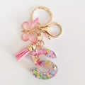 Pink resin letter S keychain with glitter, butterfly charm, and soft fabric tassel - Letter S