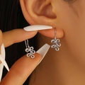 Silver minimalist knot earrings with intertwined hollow lines on female model - Intertwined Wire Knot Style (1481) / Silver