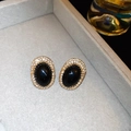Close-up of vintage black oval earrings with gold frames and sparkling rhinestones - Silver Earring Post - Gold - Black
