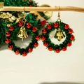 Détail de boucles d'oreilles couronne de Noël avec perles rouges et cloche dorée - Style Couronne Verte