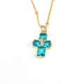 Macro shot of sky blue zircon cross pendant with gold chain and rectangle cut stones - Lake Blue