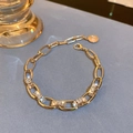 Detail of gold chain bracelet featuring square zircon pavé and round coin pendant charm - Gold