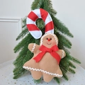 Plüsch Lebkuchenmann und Zuckerstange aus Filz hängend an einem grünen Weihnachtsbaum - Große Größe Rote Schleife Stil