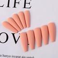 Detailed view of matte peach salmon coffin shaped press-on nails in 10-piece layout - Light Orange