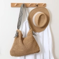 Brown straw tote bag with black and white geometric pattern strap hanging in resort style - Striped Handle / Brown