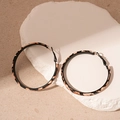 Macro shot of large hoop earrings with leopard print leather texture on display stone - Coffee Leopard Leather (Silver Pin)