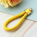 Bright yellow braided leather keychain with a golden heart charm and metal ring - Yellow