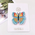 Close-up of handmade butterfly hair clip with blue glitter wings on display card - Blue Colorful Butterfly
