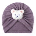 Detail of purple cable-knit baby turban hat with a cute white plush bear patch - One Size / Deep Purple