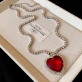 Macro view of heart-shaped red zircon pendant necklace with pavé diamond chain - Dark Red Heart Necklace