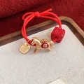 Macro detail of red elastic hair tie featuring a golden horse charm and lucky pendant - Red - Horse - Blessing (Alt)